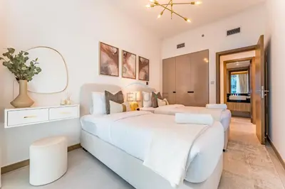 a white bedroom with two beds and a mirror at Balcony Facing a Partial Canal View, Close to Metro and Marine Transport, Downtown Attractions Just a Ride Away, Urban Oasis, Business Bay by Deluxe Holiday Homes in Dubai