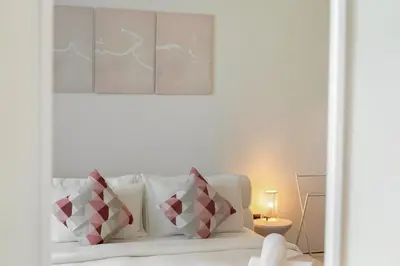a white couch with red and white pillows in a room at Modern 1BR in Dubai Marina near to Dubai Harbour in Dubai