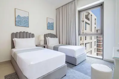 a hotel room with two beds and a window at Frank Porter - Grove at Creek Beach Building in Dubai