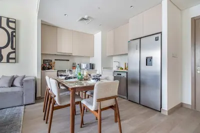 a kitchen and dining room with a table and chairs at Frank Porter - Grove at Creek Beach Building in Dubai