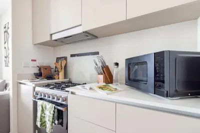 a kitchen with a microwave and a stove at Frank Porter - Grove at Creek Beach Building in Dubai