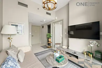 a living room with a couch and a tv at Elegant 1BR in Business Bay with Pool & Gym in Dubai