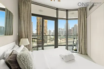 a bedroom with a white bed and a large window at Elegant 1BR in Business Bay with Pool & Gym in Dubai