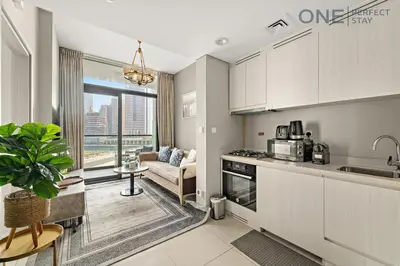 a kitchen and living room with a couch at Elegant 1BR in Business Bay with Pool & Gym in Dubai