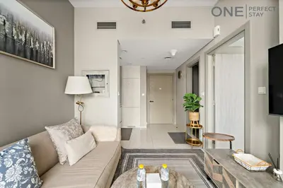 a living room with a couch and a tv at Elegant 1BR in Business Bay with Pool & Gym in Dubai