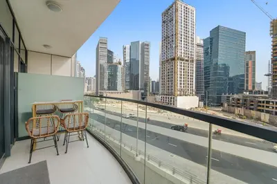 a balcony with two chairs and a view of a city at Elegant 1BR in Business Bay with Pool & Gym in Dubai