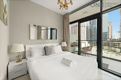 a bedroom with a white bed and a large window at Elegant 1BR in Business Bay with Pool & Gym in Dubai