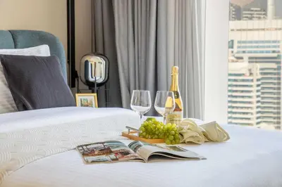a bed with a bottle of wine and wine glasses at Frank Porter - 5242 Emaar Tower in Dubai