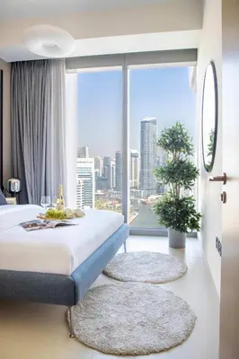 a hotel room with a bed and a large window at Frank Porter - 5242 Emaar Tower in Dubai