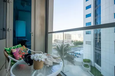 a table in a balcony with a view of a city at Frank Porter - Ocean Heights, Dubai Marina in Dubai