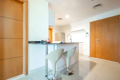 a kitchen with a counter and two stools in a room at Frank Porter - Ocean Heights, Dubai Marina in Dubai