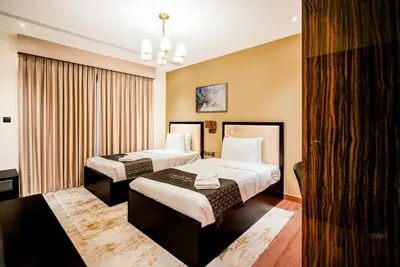 a hotel room with two beds and a chandelier at Escape24 2BR with Large Balcony near Burj Khalifa in Dubai