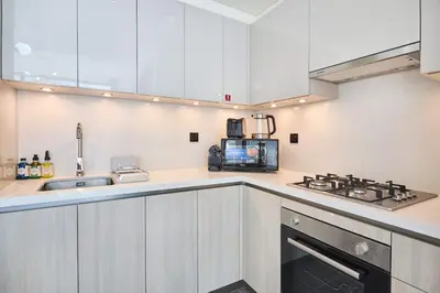 a kitchen with white cabinets and a stove top oven at The Crest C Luxury Retreat Stylish & Serene in Dubai