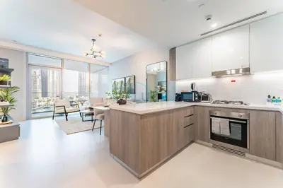 an open kitchen and dining room with a dining table at Luxury 1BR with Pool and Stunning Marina Views, Perfectly Located Minutes from the Beach, Tram, and Mall, LIV Marina, Dubai Marina by Deluxe Holiday Homes in Dubai