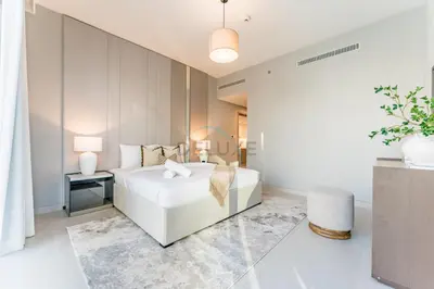a bedroom with a white bed and a table at Luxury 1BR with Pool and Stunning Marina Views, Perfectly Located Minutes from the Beach, Tram, and Mall, LIV Marina, Dubai Marina by Deluxe Holiday Homes in Dubai