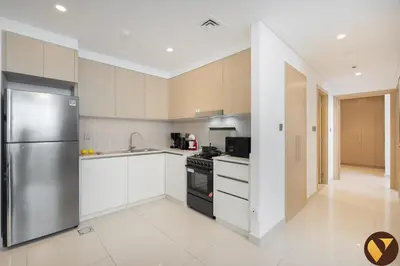 a kitchen with a stainless steel refrigerator and white cabinets at Vogue Creek Harbour Icon Bay Waterfront Living Close to Downtown, Burj Khalifa and Dubai Mall, Two Bedroom Apartment with Large Balcony and Canal View, Access to all Amenities in Dubai