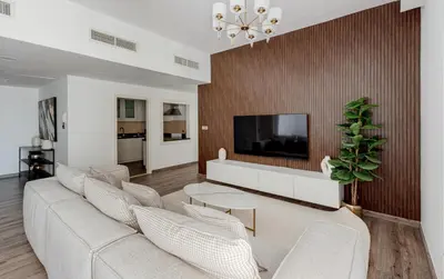 a living room with a couch and a tv at Beautiful 2 bed in JBR! bahar in Dubai