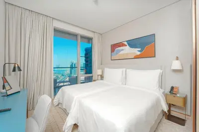 a bedroom with a white bed and a large window at Prime Stay Elite, Dubai Mall & Burj Khalifa View in Dubai