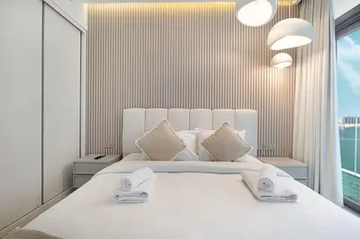 a white bedroom with a large white bed with pillows at Serene Beachfront Oasis Private Beach 4BR in Dubai