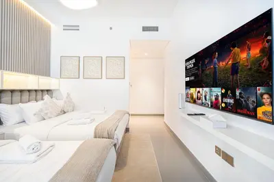 a bedroom with two beds and a flat screen tv at Serene Beachfront Oasis Private Beach 4BR in Dubai