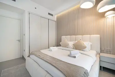 a bedroom with a large white bed with two books on it at Serene Beachfront Oasis Private Beach 4BR in Dubai