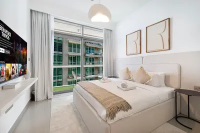 a white bedroom with a large bed and a window at Serene Beachfront Oasis Private Beach 4BR in Dubai
