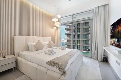 a bedroom with a large white bed with a large window at Serene Beachfront Oasis Private Beach 4BR in Dubai