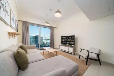 a living room with a couch and a tv at Spacious 2-Bed Marina Home with Wrap-Around Balcony in Dubai