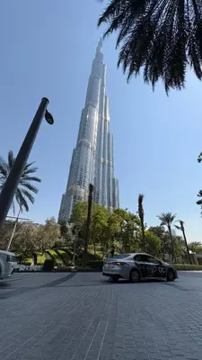 a car parked in a parking lot with tall buildings at Great 1 bed apart close to Burj Khalifa and Dubai Mall in Dubai