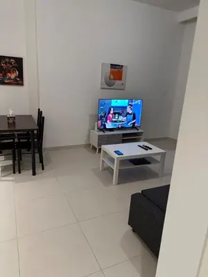 a living room with a tv and a table at Great 1 bed apart close to Burj Khalifa and Dubai Mall in Dubai