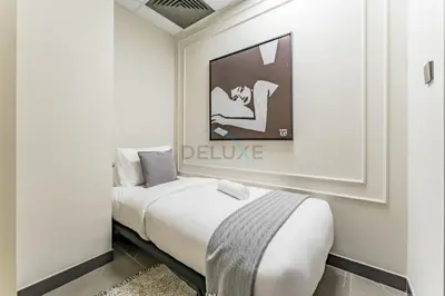 a bed in a room with a picture on the wall at Luxurious High-Floor 3BR with Assistant Room, Showcasing Lake & City Views, Just Moments Drive from JBR Beaches and Ain Dubai, MBL Royal, JLT by Deluxe Holiday Homes in Dubai