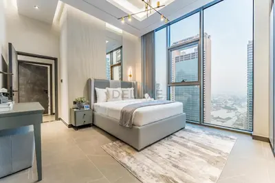 a bedroom with a large bed and large windows at Luxurious High-Floor 3BR with Assistant Room, Showcasing Lake & City Views, Just Moments Drive from JBR Beaches and Ain Dubai, MBL Royal, JLT by Deluxe Holiday Homes in Dubai