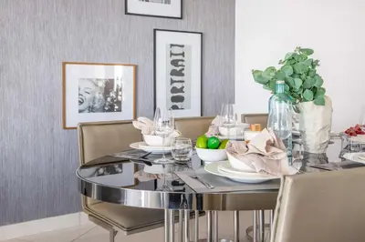 a dining room with a glass table and chairs at Frank Porter - Paramount Tower A in Dubai