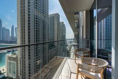 a balcony with two chairs and a view of the city at Luxury 1BR with Private Beach & Pool! in Dubai