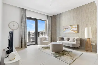 a living room with a couch and a tv at Bright 1BR with Balcony Creek Beach Access in Dubai