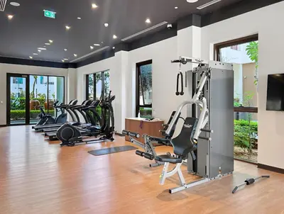 a gym with treadmills and elliptical machines at Bright 1BR with Balcony Creek Beach Access in Dubai