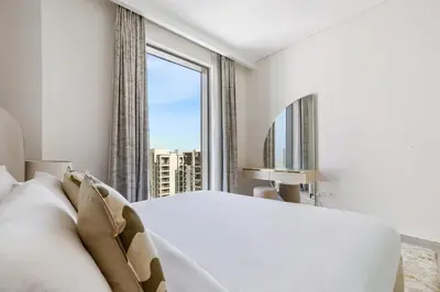 a bedroom with a white bed and a large window at Bright 1BR with Balcony Creek Beach Access in Dubai