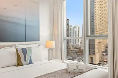 a bedroom with a white bed and a large window at FIRST CLASS 1BR Scenic Marina Views in Dubai