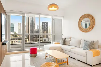 a living room with a white couch and a large window at FIRST CLASS 1BR Scenic Marina Views in Dubai