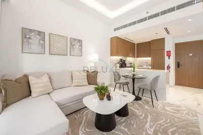 a living room with a white couch and a table at Perfectly Positioned Near the Park and Meydan Racecourse, Just a 20-Minute Drive to Global Village, Azizi Riviera 65, Al Merkadh by Deluxe Holiday Homes in Dubai