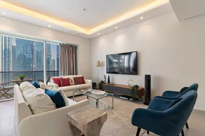 a living room with a couch and a tv at The Smart Concierge - Marina tower in Dubai