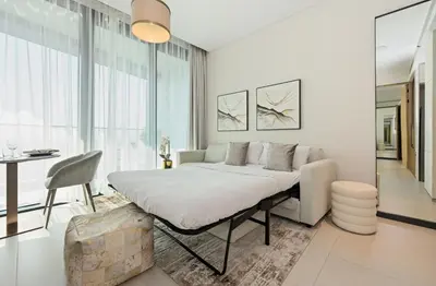 a white bedroom with a bed and a table at New & Beautiful 1BD Apartment in Address JBR in Dubai