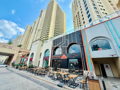 a street with tables and chairs in front of a building at New & Beautiful 1BD Apartment in Address JBR in Dubai