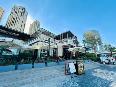 a building with plants and umbrellas in a city at New & Beautiful 1BD Apartment in Address JBR in Dubai
