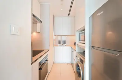 a kitchen with a refrigerator and a washer and dryer at New & Beautiful 1BD Apartment in Address JBR in Dubai
