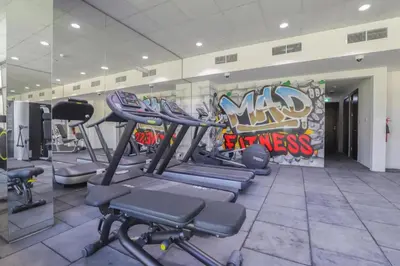 a gym with tread machines and a wall with graffiti at Joya Verde Residence - Studio with Balcony in Dubai