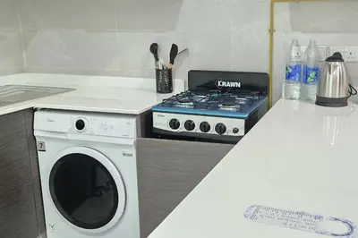 a kitchen with a stove and a washing machine at Joya Verde Residence - Studio with Balcony in Dubai