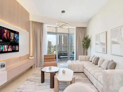 a living room with a couch and a tv at Royal Vista - Luxe 4BR Penthouse with Burj Khalifa View at Imperial Avenue - Downtown in Dubai