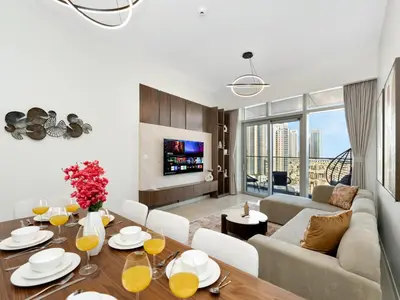 a living room with a table and a couch at Royal Vista - Luxe 4BR Penthouse with Burj Khalifa View at Imperial Avenue - Downtown in Dubai