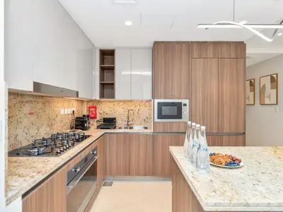 a kitchen with a stove and a counter top at Royal Vista - Luxe 4BR Penthouse with Burj Khalifa View at Imperial Avenue - Downtown in Dubai